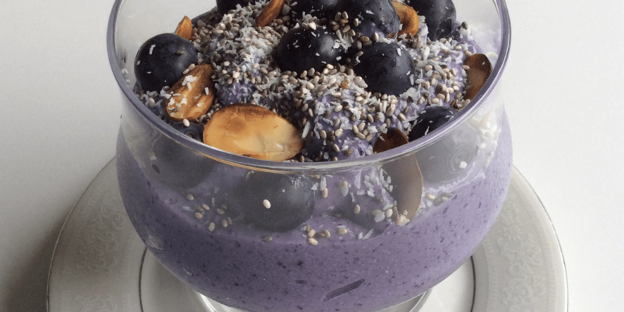 Blueberry and coconut mouse served in a glass cup