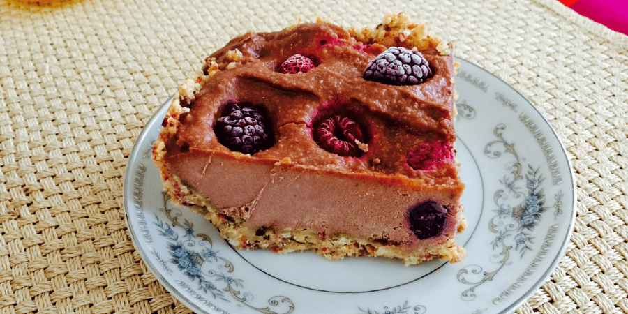 A slice of frozen chocolate cheesecake served on a patterned plate.