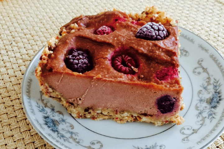 A slice of frozen chocolate cheesecake served on a patterned plate.