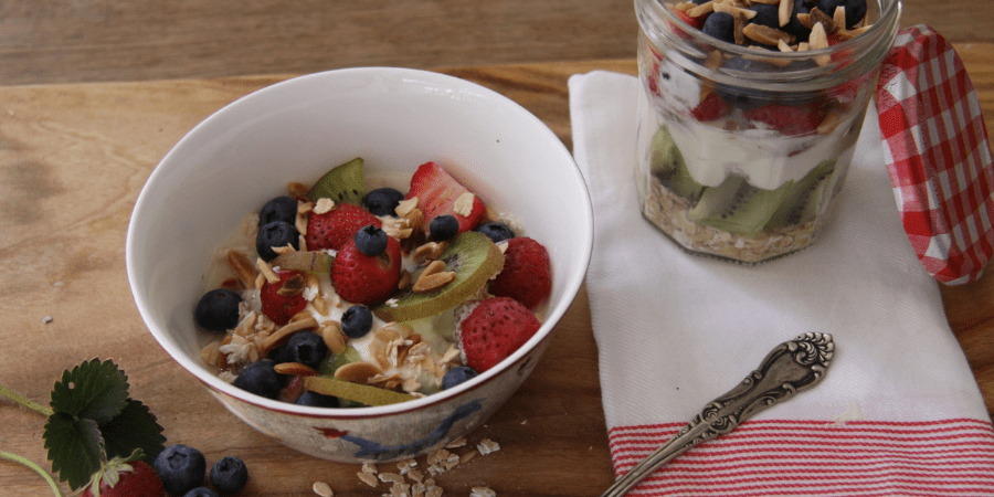 Cereal in a bowl with kiwifruit, strawberries and blueberries
