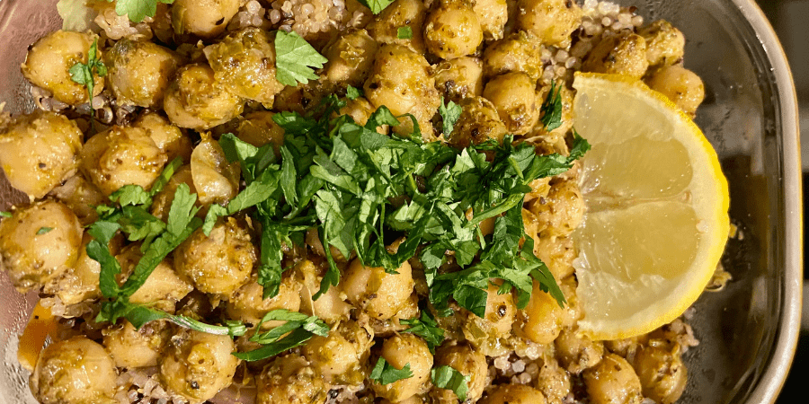 Pesto covered chickpeas with a lemon slice and green garnish