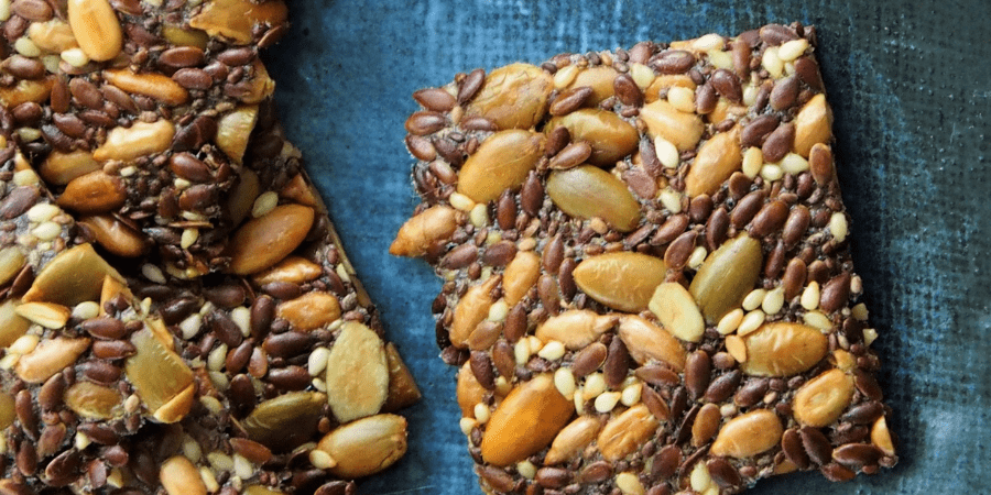 A close-up of seedy crackers on a blue background.