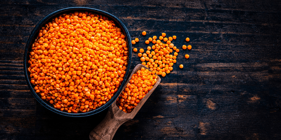 Red lentils in a bowl on a wooden table